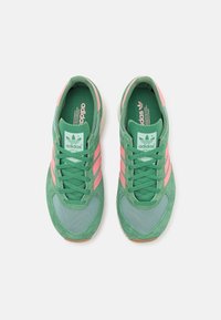 Gröna och rosa Adidas-sneakers med ovandel i mocka och mesh, tre rosa ränder och en texturerad gummisula.