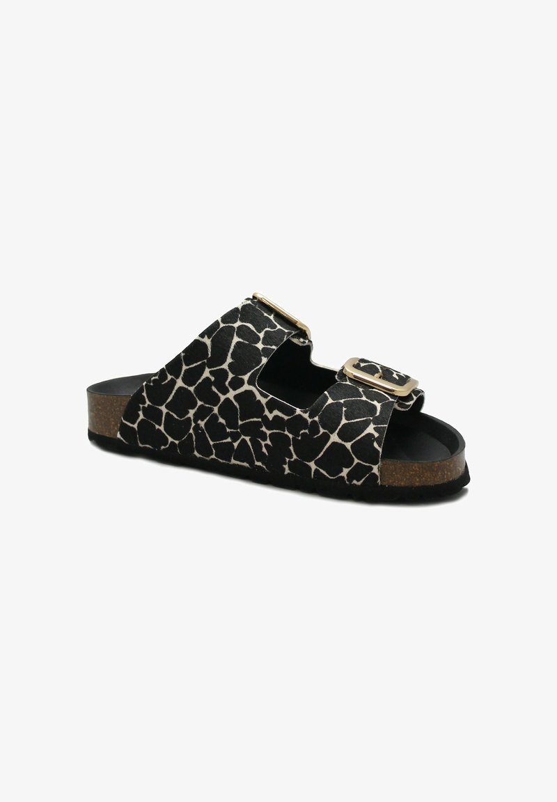 Sandalo in stampa giraffa bianco e nero con due fibbie dorate regolabili e suola in sughero, mostrato su sfondo bianco.