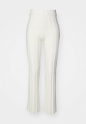 Pantalones acampanados blancos de punto trenzado con un patrón texturizado, que cuentan con una cinturilla elástica. La tela parece suave y ligeramente elástica.