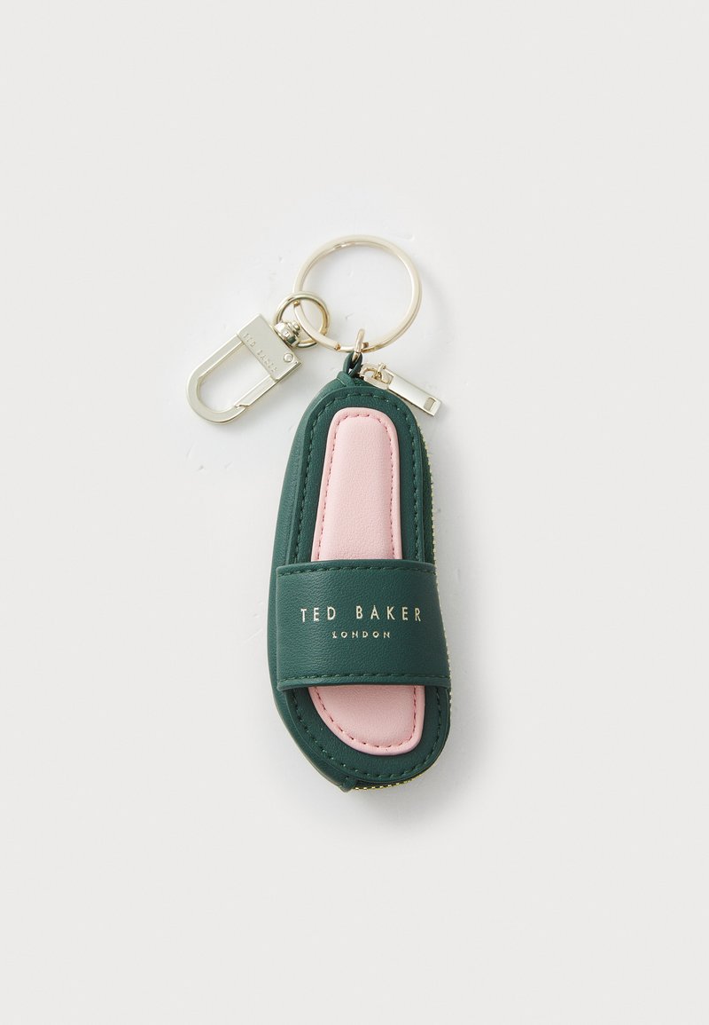 Green and pink leather keychain in a sandal shape, featuring gold logo text and a gold hardware clasp. Smooth texture with contrasting colors.