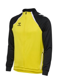 Chaqueta deportiva amarilla y negra con cierre de cremallera frontal, cuello alzado y detalles en blanco, fabricada con un tejido suave y ligero.