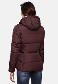 Brown puffer jacket with a hood, featuring quilted insulation, side pockets, and a logo patch on the left arm. Smooth, water-resistant material.