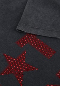 Donkergrijs katoenen T-shirt met een groot rood sterontwerp versierd met glanzende rode strassteentjes. De uiteinden van de mouwen zijn netjes afgewerkt.