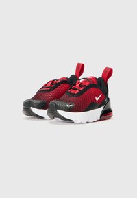 Baskets de sport noires et rouges avec une tige en mesh, un col rembourré et une semelle extérieure blanche. Présente un logo et une languette au niveau du talon.