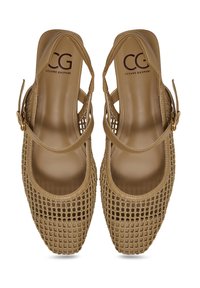 Zapatos de malla tejidos en tono beige con puntera redondeada, correa al tobillo y acentos de metal dorado. Con forro interior suave y diseño abierto.