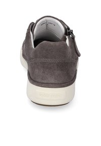 Chaussure en daim gris avec un bout arrondi, un col rembourré, une fermeture éclair sur le côté et une semelle en caoutchouc blanche avec le nom de la marque embossé sur le côté.