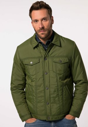 Giacca trapuntata verde oliva con chiusura a bottoni, due tasche sul petto e dettagli in denim. Presenta un colletto classico e un tessuto strutturato.
