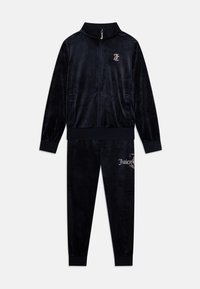 Velvet trenirka v temno črni barvi, ki vključuje jakno z zadrgo in visokim ovratnikom, dvema stranskima žepoma ter usklajenimi hlačami z logotipom, okrašenim s kristali.
