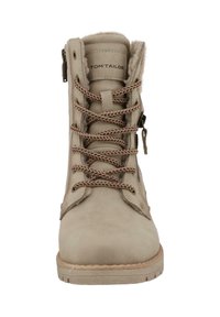 Bottine beige avec une texture en cuir lisse, dotée de lacets marron, d'une fermeture éclair sur le côté et d'une semelle en caoutchouc. Nom de la marque visible sur la languette.