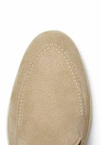 Beige suede slip-on shoe with a smooth texture, rounded toe, and contrast stitching along the edge. Sole is white rubber.