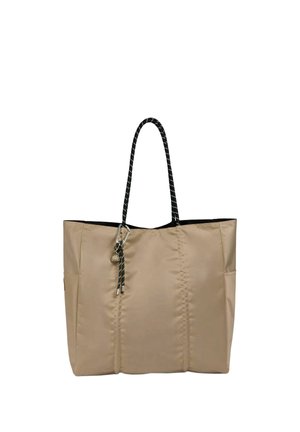 Borsa beige con manici in corda bianca e nera e un piccolo ciondolo in metallo attaccato vicino al manico.