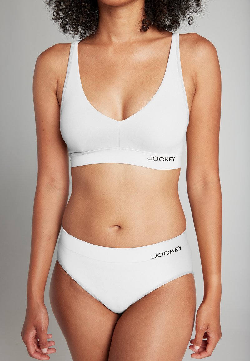 Set di bralette e bikini bianco con una texture liscia, design a V e logo Jockey sottile sulla fascia. Design semplice e minimalista.