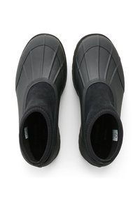 Mustat nilkkurit, joissa on sileä kumipinta ja teksturoitu yläosa. Suunnittelussa on pyöreä kärki ja joustavat sivupaneelit.