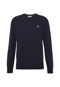 Navy blue sweater made of soft knit fabric, featuring a round neckline and long sleeves with ribbed cuffs. Lacoste logo patch on chest.