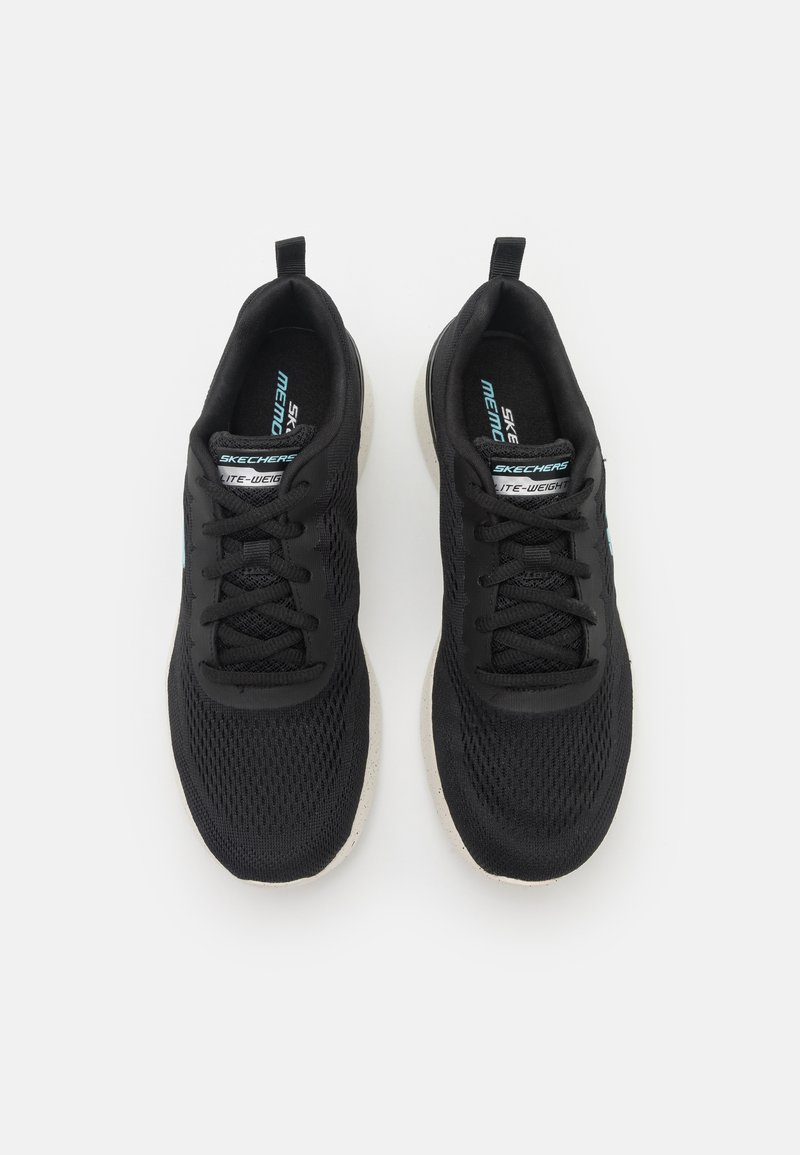 Zwarte sportieve schoenen met mesh materiaal, textuur bovenkant en lichte zool. Kenmerken zijn onder andere veters en branding op de tong.