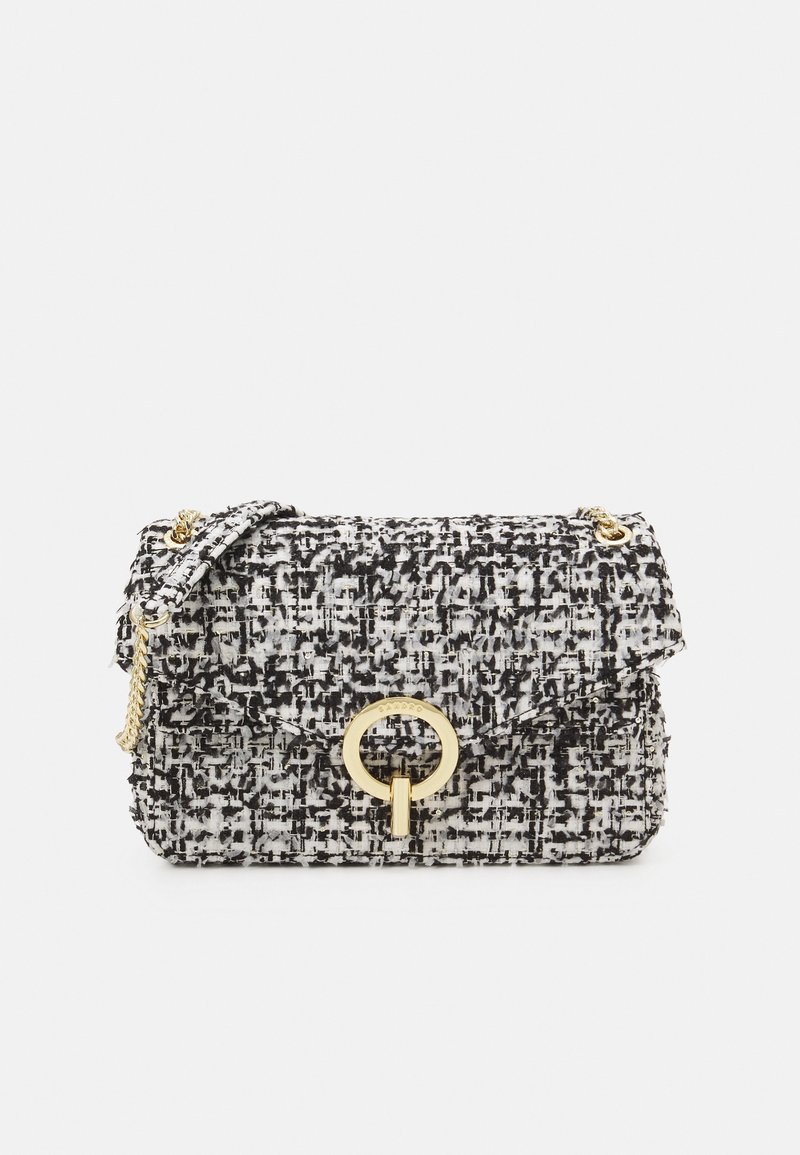 Sac à main en tweed noir et blanc avec une boucle circulaire dorée et une bandoulière chaîne. Tissu texturé avec une fermeture à rabat et des détails de motif subtils.