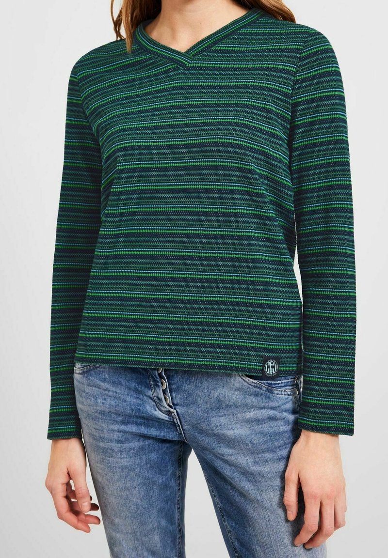 Grön och marinrandig långärmad topp med V-ringning, som har ett texturerat tyg och en liten logotyp patch vid fållen.