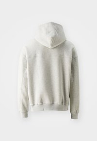 Szary hoodie wykonany z miękkiej, gładkiej mieszanki bawełny. Posiada kieszeń typu kangur i ściągacze na rękawach, z bezszwowym wykończeniem na ramionach.