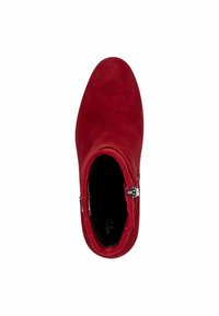 Botte de cheville en suède rouge avec une texture lisse, bout rond et détail de fermeture éclair sur le côté ; l'intérieur est noir avec un marquage visible.