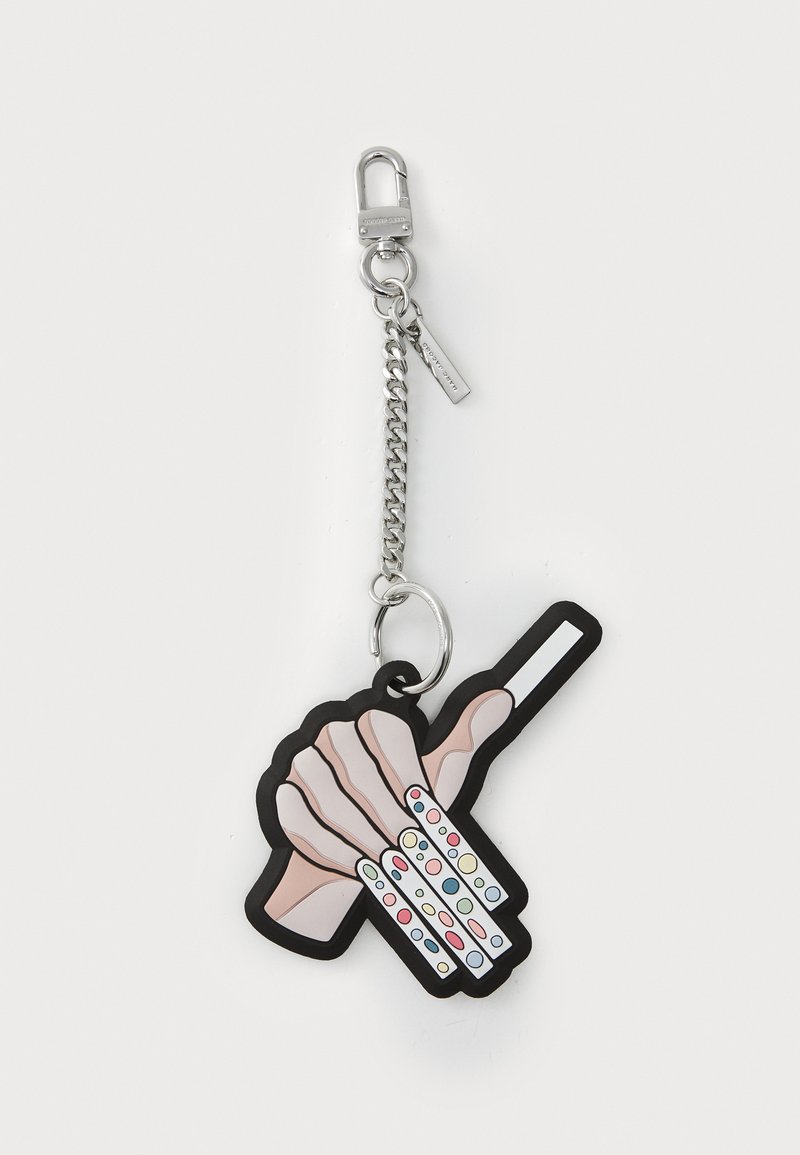 Gummi-Schlüsselanhänger in Handform, rosa mit schwarzem Rand, die einen weißen Stock hält. Angeschlossen an eine silberne Kette und einen Clip.