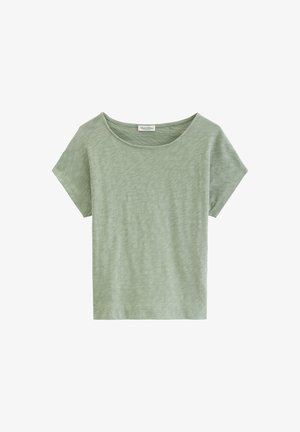 T-shirt pour femmes à manches courtes de couleur vert clair avec un col rond, fabriqué en tissu de coton slub, présenté sur un fond blanc.