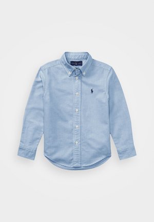 Lichtblauw overhemd met lange mouwen, knoopsluiting, met knoopkraag en klein marineblauw geborduurd logo op de linkerborst.