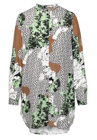 Langærmet skjorte med knapper, der har et patchwork-design med grønne, brune og sorte blomster mønstre på en hvid baggrund. Blødt stof.