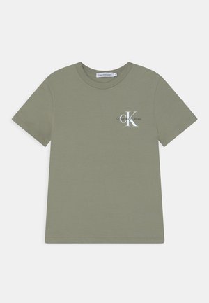 Olivově zelené tričko z měkké bavlny, s krátkými rukávy, klasickým kulatým výstřihem a bílým logem "CK" na levé straně hrudi.