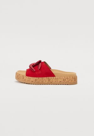 Red suede slide sandal with a chunky cork sole. Features a thick decorative chain accent on the upper and a textured rubber outsole.