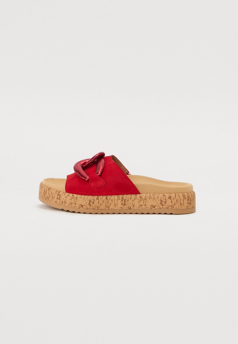 Röd mocka slingback-sandal med en kraftig korksula. Har en tjock dekorativ kedjeaccent på ovansidan och en texturerad gummiyttersula.