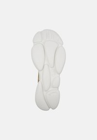 Shoe sole featuring a white, textured finish with curved shapes and cushioning elements, designed for comfort and grip.