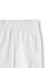 Helle graue Jogginghosen aus Baumwoll-Mischgewebe mit einem elastischen Bund und seitlichen Taschen, die über eine weiche Textur und eine lockere Passform verfügen.
