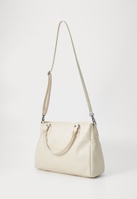 Sac à main beige en synthétique, avec un design structuré, deux poignées, une bandoulière ajustable et des accents en métal argenté.