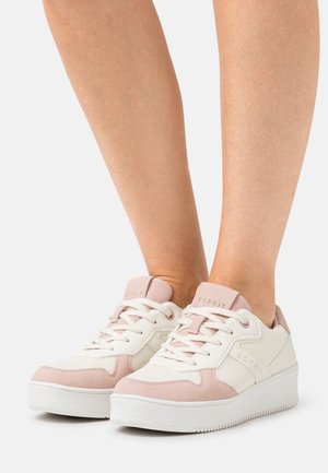 White sneakers with pink accents, made of leather and fabric, featuring a textured surface, round toe, and lace-up design.