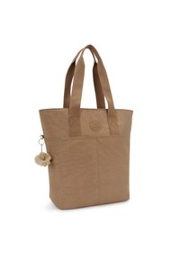Tan tote bag made of textured fabric, featuring two sturdy handles and a keychain with a fluffy bear charm. Circular logo on the front.