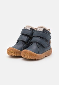Zilas ādas potītes zābaki ar diviem regulējamiem Velcro siksnām, mīkstu iekšējo oderi un strukturētu gumijas zolīti.