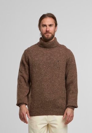 Braun gesprenkelter Strickrollkragenpullover mit lockerer Passform und gerippten Bündchen, getragen über hellcremefarbenen Hosen. Strukturierte, kuschelige Optik.
