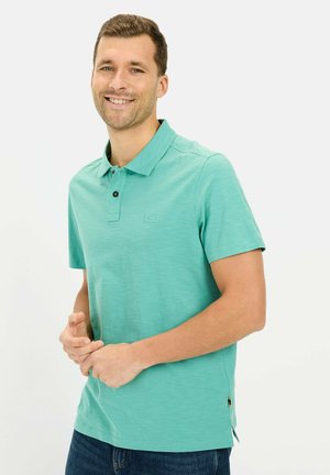 Lys teal polo shirt med collaret halsudskæring, tre knaplukninger, korte ærmer og en subtil tekstur. Har logo-detalje på brystet.