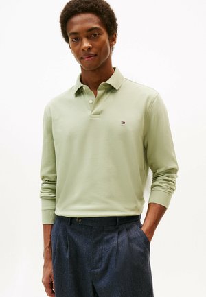 Polo de manga larga en verde claro con cuello y tapeta de tres botones. Cuenta con un pequeño logotipo en el pecho. Tejido de algodón texturizado.