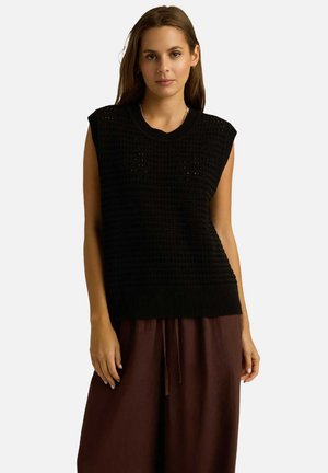 Czarny dzianinowy top bez rękawów z teksturowanym wzorem, posiadający okrągły dekolt i prążkowany dół, w zestawieniu z brązowymi, luźnymi spodniami.