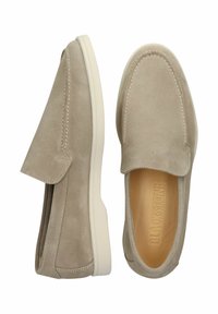 Zapatos slip-on de ante en beige claro con suelas de goma crema, que presentan detalles de costura y un interior acolchado para mayor comodidad.