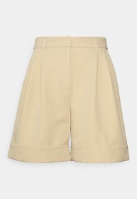 Jasnobeżowe, wysokie szorty z zakładkami, kieszeniami po bokach i podwiniętymi brzegami. Wykonane z gładkiego materiału o strukturalnym designie.