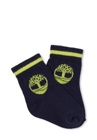 Calzini blu navy con strisce gialle e design di un logo ad albero. Realizzati in morbido tessuto a maglia con un taglio alla caviglia.