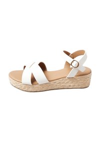 Sandalo con zeppa espadrilla bianco, con cinturini incrociati, dettagli in corda naturale sulla suola e chiusura con fibbia tonda.