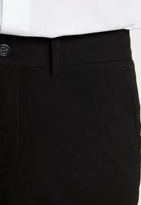 Svarta byxor i slät tyg, med knappstängning, rak passform och fickor med sydda detaljer.