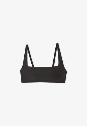 Bralette nero minimalista con sottili spalline regolabili e scollo dritto, posato su uno sfondo bianco.