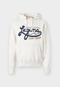 Felpa crema con tasca frontale, caratterizzata da ricamo in blu navy e marrone con la scritta "Laguna Surf Crew". Cappuccio con cordino regolabile.