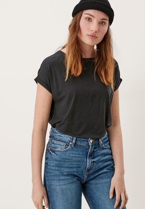 Schwarz, kurzärmliges Hemd mit umgeschlagenen Ärmeln. Weiches Material. Hoch geschnittene blaue Jeans mit klassischen Taschen und Knopfverschluss. Einfaches, lässiges Design.