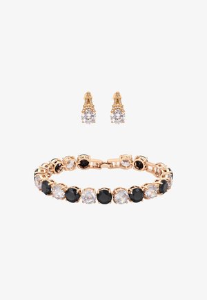 Aranyszínű karkötő, váltakozó nagy fekete és átlátszó kerek kövekkel, aranyszínű fülbevalókkal párosítva, melyeken csillogó kerek kövek találhatók.