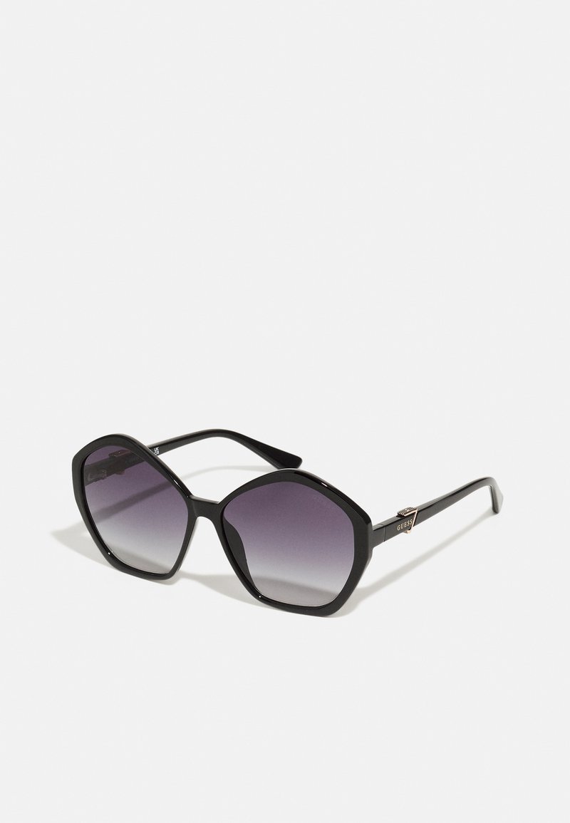 Svarte, oversized solbriller med heksagonal ramme, gradient lilla linser og glitrende gullhardwaredetaljer på tempelene.